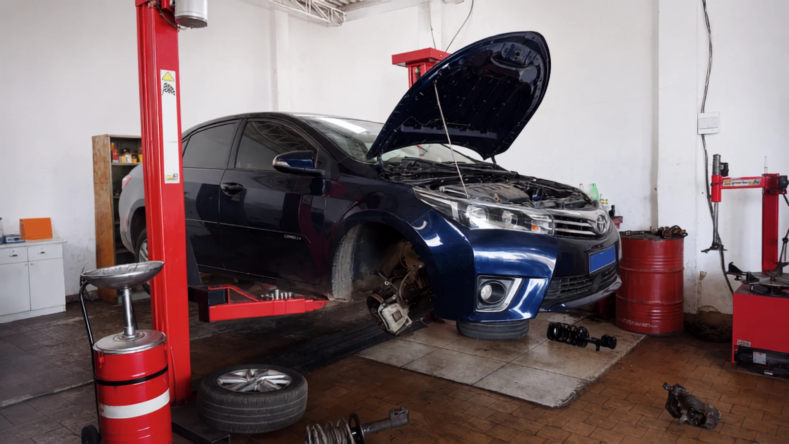 Carro suspenso no elevador de duas colunas na área interna da Dolla Auto Center.